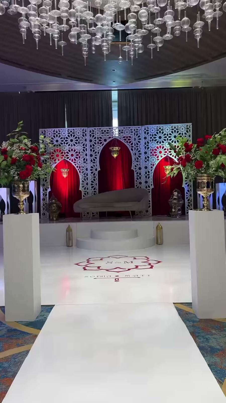 Décor de mariage signé Supreme Mariage : scène, allée blanche et roses rouges